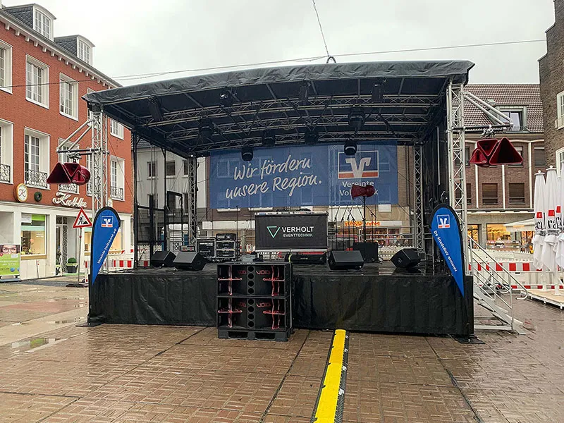 Eine Mobile Bühne steht auf dem Marktplatz in Dorsten und ist für ein Event mit verschiedener Eventtechnik ausgestattet.